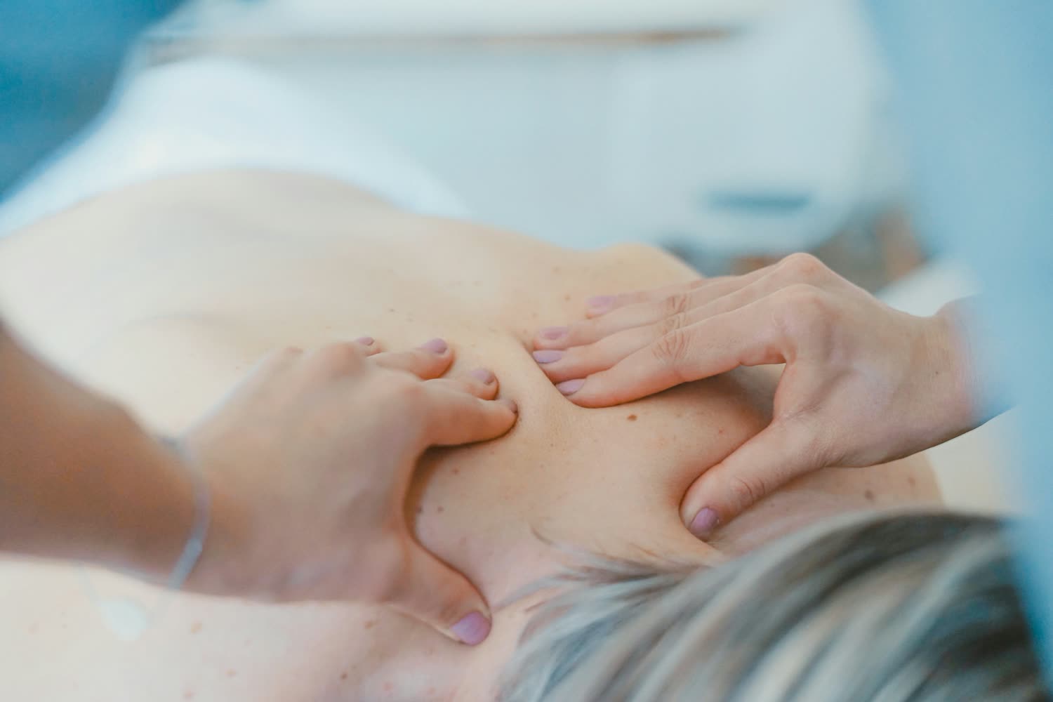 Hände massieren sanft den Rücken während einer Ayurveda-Massage